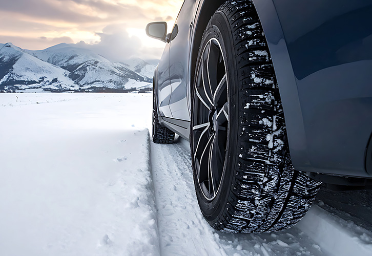 cars driving on curved road in snowy weather with low visibility winter travel safety tips 4